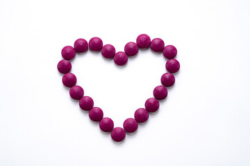 Heart laid out of burgundy tablets for Valentines Day.