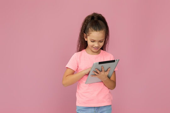 Little Child Girl In Headphones Using Digital Tablet