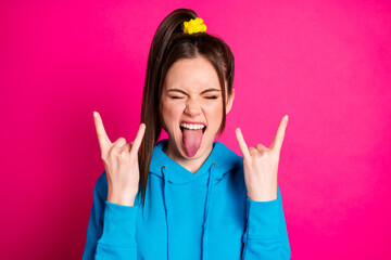 Portrait of excited young lady closed eyes tongue out fingers show heavy metal symbol isolated on...