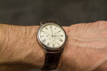 watch on the table, The clock on my hand reads 3:00 p.m., three o'clock in the afternoon