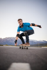 Close up image of a skateboarder skating his skateboard down the road.
