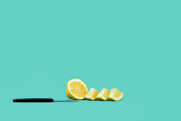 lemon cut into pieces and a knife on blue. Front view copy space. Healthy lifestyle, weight...