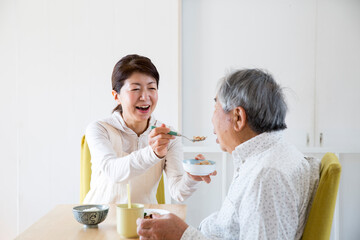 食事介助する日本人のミドル女性、在宅介助、ヘルパー