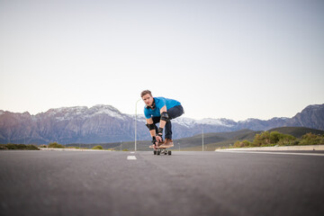Obraz premium Skateboarder skateboarding on an open road doing freestyle tricks
