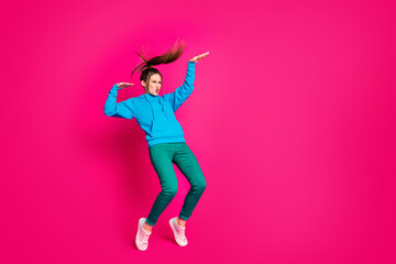 Fototapeta na wymiar Full length photo of pretty funky young woman dressed blue hoodie dancing standing tiptoes isolated vibrant pink color background