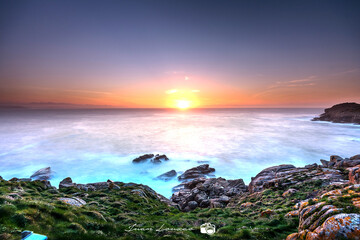 Fototapeta premium Puesta de sol con tonos naranjas y azules, visto desde la costa gallega