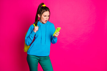 Photo of sad shocked lady wear blue sweater rucksack chatting modern device empty space isolated bright pink color background