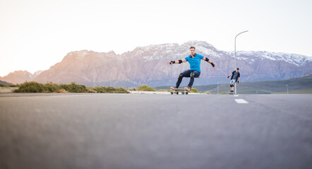 Obraz premium Skateboarder skateboarding on an open road doing freestyle tricks