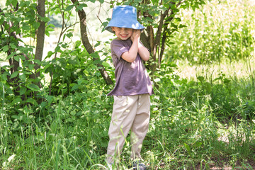 A walk in the park of a curly-haired boy. Sunny weather, the park is all in multi-colored colors