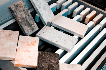 Samples of acrylic stone for kitchen countertops in a special case to show to clients in the salon.