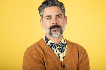 Fototapeta premium Photo of a mature man, isolated on a yellow wall background