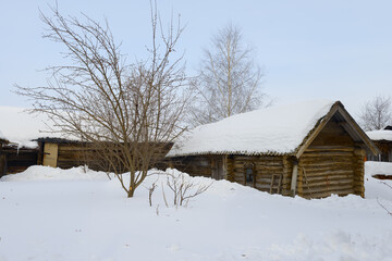 Rustic snow-covered courtyard with old log buildings