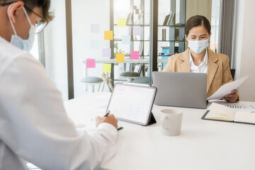 Asian People Successful Teamwork Business Wearing Medical Mask and Working. Work from Private Office Social Distancing among Coronavirus Outbreak Situation