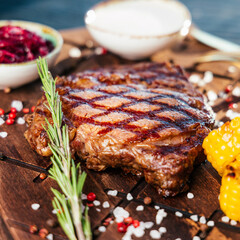 steak on a board with baked corn