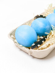 Easter eggs in a carton box on a white background.