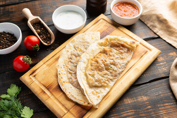 Board with Qutabs and sause on dark rustic wooden table