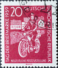 GERMANY, DDR - CIRCA 1959 : a postage stamp from Germany, GDR showing a mail delivery woman with a...