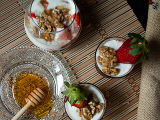 Natural and healthy dessert of yogurt, honey, strawberries and walnuts