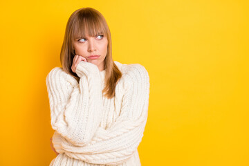 Portrait of unsatisfied sullen lady hand on cheek look empty space wear warm pullover isolated on yellow color background