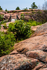 A wooden footbridge over rugged granite rocks on a trail along the coast of Georgian Bay. Killarney Provincial Park, Ontario,  Canada