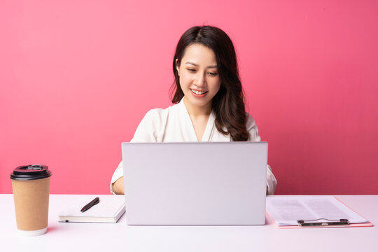 Young Asian businesswoman sitting working with expression on background