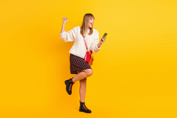 Fototapeta premium Full length profile portrait of astonished lady fist up open mouth celebrate isolated on yellow color background