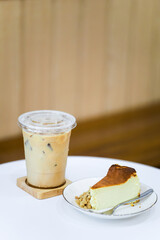 Basque cheesecake burnt bakery and delicious cheesecake with a glass of iced coffee on the table.