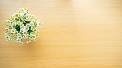 Put a bottle of white chrysanthemums on a clean wood grain table