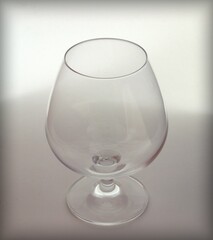Empty cognac glass on a white background with shadows