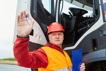 Vorarbeiter oder Bauleiter am LKW gibt Handzeichen