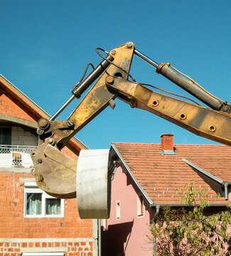 Loading bucket excavator lifts the concrete cylinder in a populated area