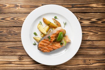 Grilled salmon steak with baked potatoes and lime