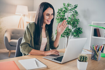 Photo of young beautiful attractive happy positive smiling cheerful lovely woman in glasses has video call says hi at home house