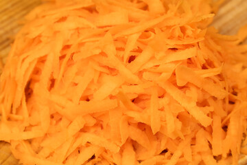 Grated fresh carrots on a plate background, macro