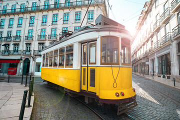 Fototapeta na wymiar A famous yellow tram on a sunny summer day in Lisbon city old town, Portugal. Trams in Lisbon. Tourist attraction 