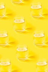 Summer pattern with glasses of lemonade on yellow background.
