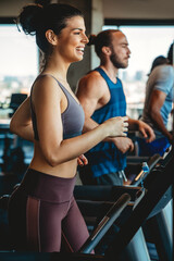 Group of young people running on treadmills in sport gym