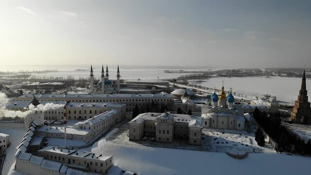 Aerial Kazan city center Kremlin at winter sunny day. Ortodox church and mosque. Traffic. Near Volga river. Aerial view. Flying over. Drone is moving left. High quality 4k footage