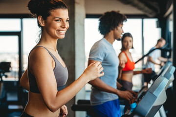 Fitness, sport, training, gym concept. Group of smiling people exercising in the gym