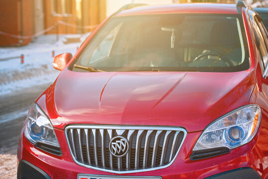 Minsk, Belarus. Feb 2021. Red Buick Encore parked at city street at sunny day. Buick American automobile manufacturer - General Motors division..