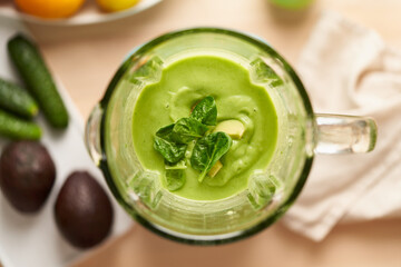 Close up whiping mixture of fruits and vegetables in blender. Preparing vegan green smoothie made from fresh ingredients. Healthy food. Lifestyle wellness. Foodism, rawism, raw food diet, top view