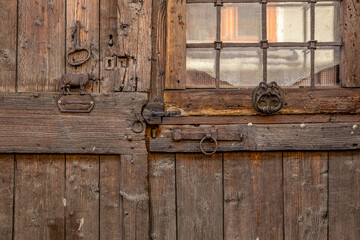 old wooden door with steel locking lever in a small isolated village in the French Alps