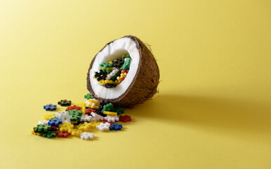 Sliced ​​coconut with colored puzzles on a yellow background