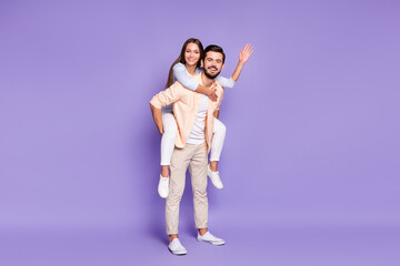 Full body profile portrait of nice cheerful guy lady piggyback arm palm wave isolated on purple color background