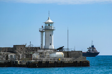 Yalta lighthouse on a sunny summer day against the backdrop of the azure sea.