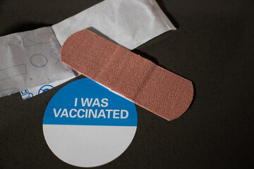 Covid Vaccinated Sticker with band aid on a black background
