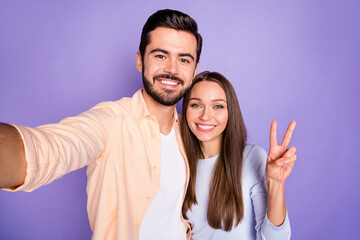 Photo of romantic brown haired spouses make selfie nice smile woman make v-sign hello isolated on violet color background