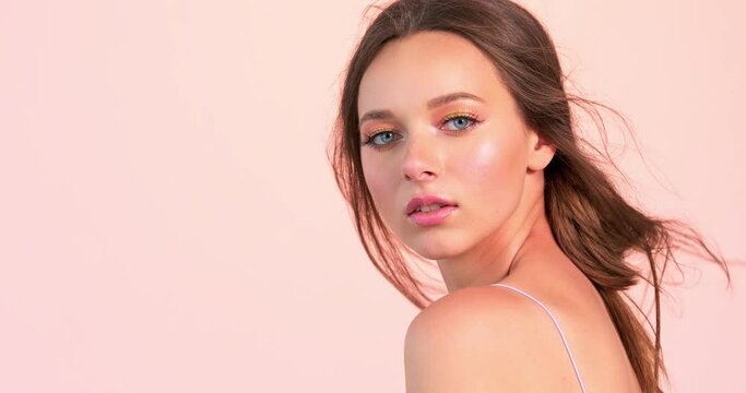 Beautiful woman with long brown hair and bright makeup. Sexy model with a languishing look posing to the camera at studio. Face of an attractive brown-haired woman. Sexy model with a sexy look.