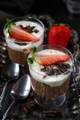 Sweet chocolate mousse dressed with whipped cream and strawberry