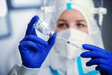 Detail closeup of syringe needle and ampoule , nurse taking injection shot,hands in blue protective gloves holding vaccination equipment,immunization against Corona virus,COVID-19